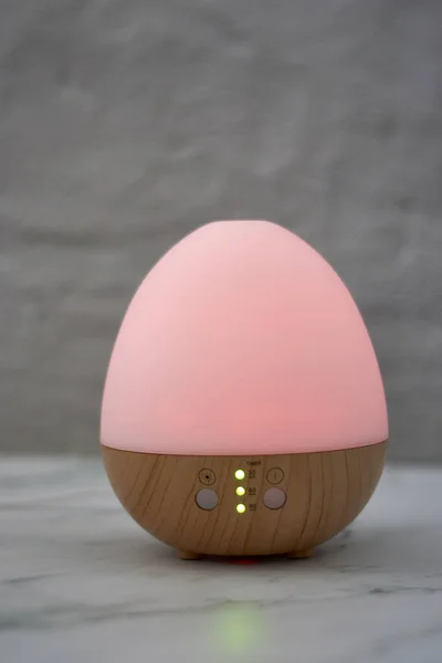 Tahta Masanın Üzerinde Bir Duvara Karşı Yumurta Şeklinde Bir Nemlendirici — Stok fotoğraf