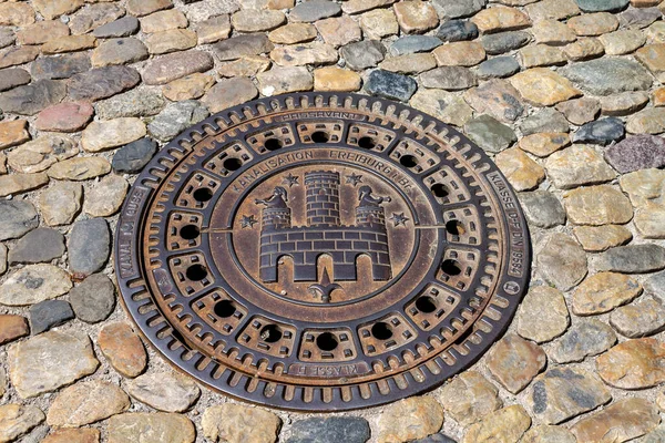 ドイツ フライブルクのダウンタウンの石の通りに鉄のマンホールの城の看板 — ストック写真