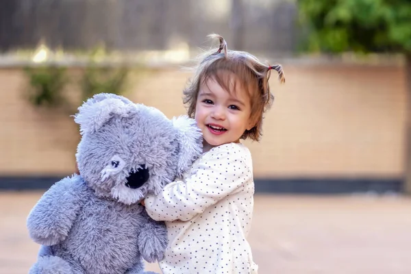 Glimlachend Kind Knuffelen Haar Teddy — Stockfoto