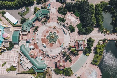 Güneşli bir günde yeşil ağaçlarla çevrili bir kasabanın kuş bakışı manzarası.