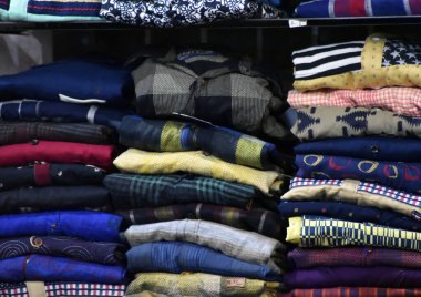 Erkeklerin farklı kollu pamuk takımı. Bir sürü renkli damalı resmi erkek gömleği askıda asılı duruyor.,