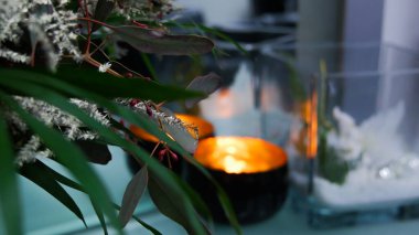 Bir mum ve bir pencere mührünün üzerindeki dekoratif çiçeklerin yakın çekimi.