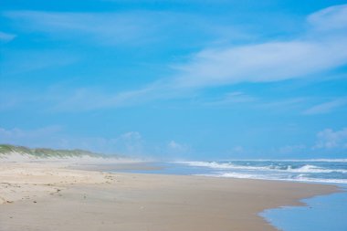 Kuzey Carolina 'daki Ocracoke Adası' nda güzel bir kumlu plaj ve mavi gökyüzü manzarası
