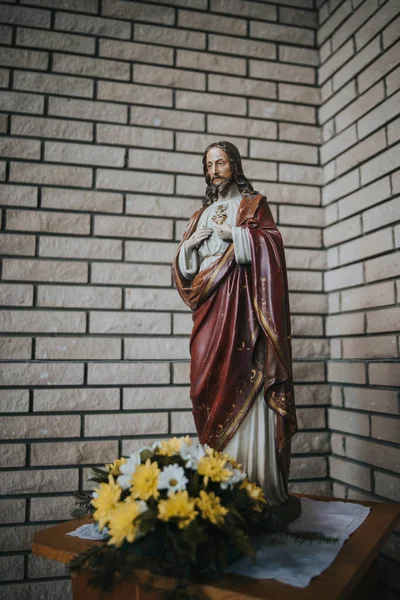 Plano Vertical Escultura Jesucristo Con Flores Decorativas Frente Ella — Foto de Stock