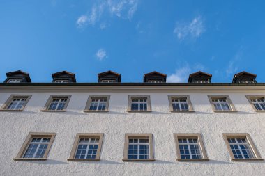 İsviçre, St. Gallen 'de mavi gökyüzünün altında beyaz bir binanın alçak açılı görüntüsü.