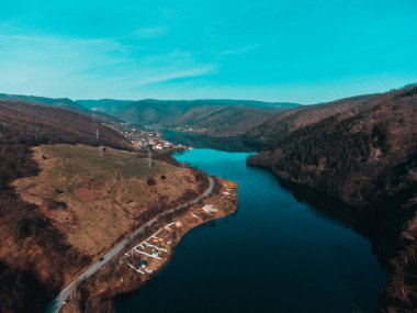 Yeşil tepeler arasında şehir ve nehrin havadan görünüşü