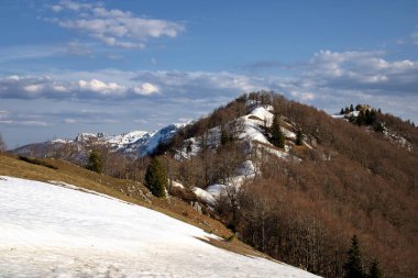 Mavi gökyüzüne karşı karla kaplı bir dağ manzarası