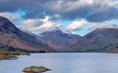 İngiltere 'nin Lake District bölgesindeki bir göl boyunca dağların ve kayalıkların güzel bir görüntüsü.