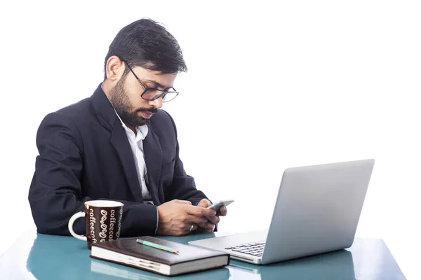 白い背景の机の上のノートパソコンの前で携帯電話を入力する弁護士 — ストック写真