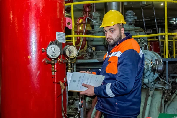 Primer Plano Trabajador Mirando Una Máquina Escribiendo Notas Con Casco —  Fotos de Stock