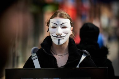 Büyük Britanya sokaklarında isimsiz maskeler takan bazı aktivistler