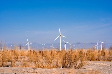 Mavi gökyüzü arka planında kırsal bir alanda yel değirmenlerinin manzarası