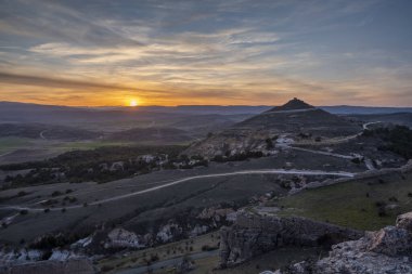 İspanya 'nın Guadalajara eyaletindeki dağlarla çevrili şehir üzerinde renkli bir günbatımı.
