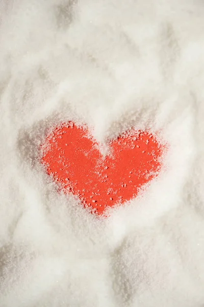 A vertical top view of a heart shape made in a white powder