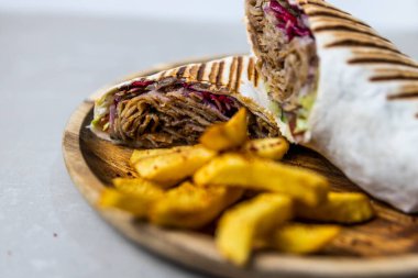 Et Quesadilla 'sının yakın plan çekimi. Yanında da ahşap bir tabakta sos var.