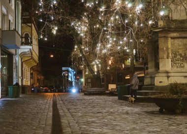 Binalarla çevrili parlayan ampullerle dolu bir sokak manzarası