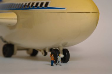 İki yolcu büyük bir uçağın önünde yürür.