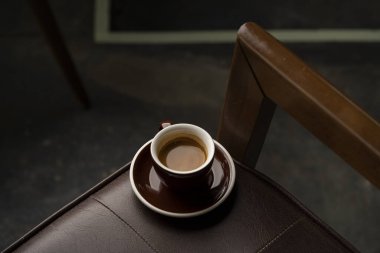 Deri bir sandalyede bir fincan kahvenin üst görüntüsü