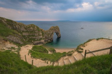 Kumsaldan çekilen denizin üzerindeki bulutlu gökyüzü