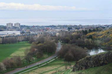 Şehir manzarasına karşı gölü olan yeşil parkın kuş bakışı görüntüsü. Edinburgh, İskoçya.