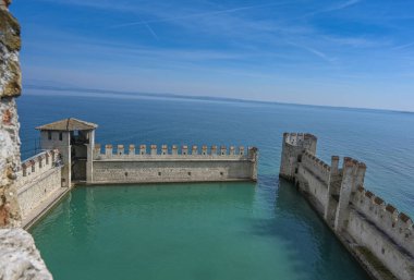 Arkasında gökyüzü olan bir denizin üzerindeki taş bir çitin güzel manzarası.