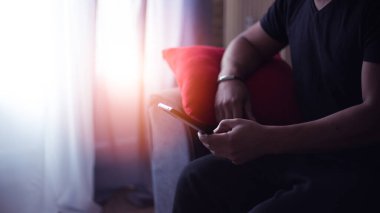 Evde cep telefonunu kullanan yakışıklı adam.