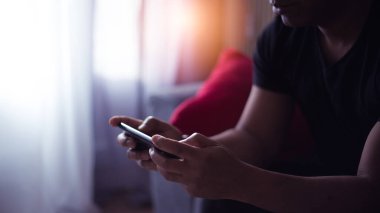 Evde cep telefonunu kullanan yakışıklı adam.