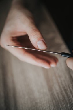 Tırnaklarını tırnak törpüsüyle törpüleyen bir kadının yakın plan fotoğrafı.