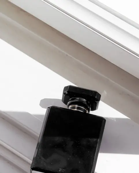 Güneş Işığıyla Beyaz Bir Pencere Kenarında Siyah Parfüm Şişesinin Yakın — Stok fotoğraf