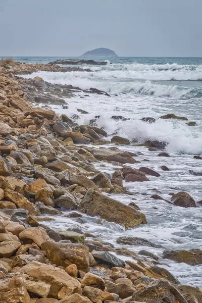 Pionowe Ujęcie Morza Lub Oceanu Falami Rozbryzganymi Skałach Żwirze Rozrzuconym — Zdjęcie stockowe