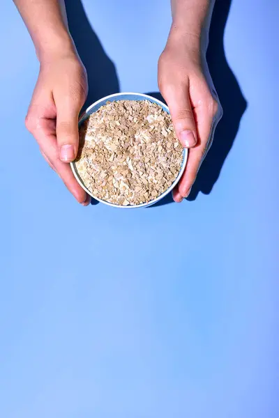 Person Hands Holding Bowl Oat Flakes Blue Background — Stock Photo, Image