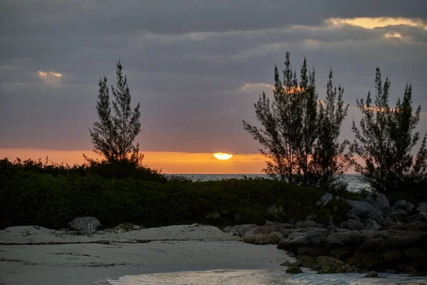 海岸の前景が雲に覆われた黄金の夕日 — ストック写真