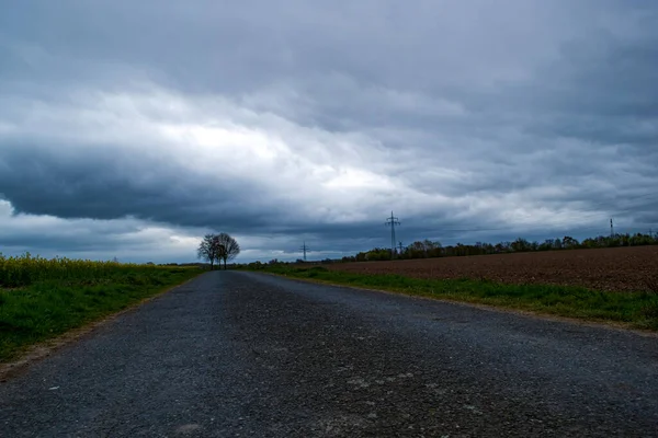 Асфальтовая Дорога Через Поля Темном Облачном Фоне Неба — стоковое фото