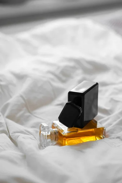 Eine Vertikale Aufnahme Von Zwei Parfümflaschen Auf Einem Weißen Bettlaken — Stockfoto