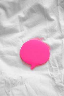 Beyaz bir çarşaf üzerinde renkli baloncuk şekilli yapışkan kağıtların dikey çekimi