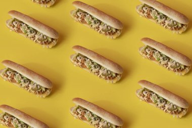 Salatalı sandviç manzarası düz sarı arka planda lezzetli görünüyor.