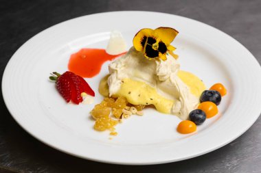 Beyaz bir tabağın yakın çekiminde çeşitli soslu böğürtlenler var.