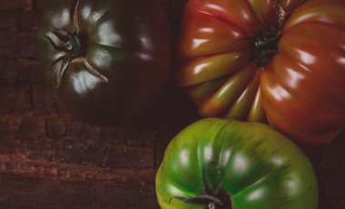 Ahşap bir masada aile yadigarı domateslerin yakın çekimi.