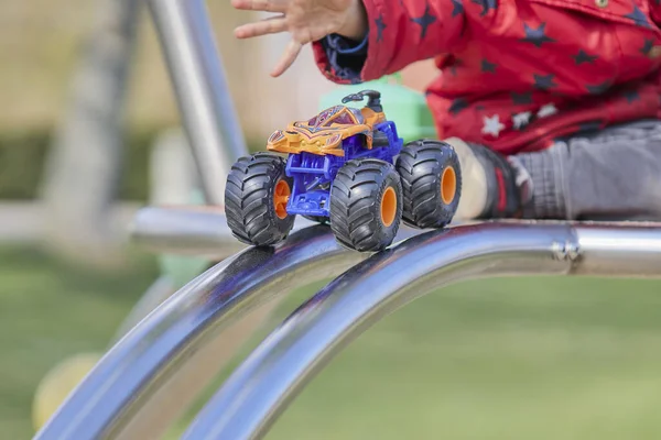 一个小孩在操场上玩火轮怪物卡车 — 图库照片