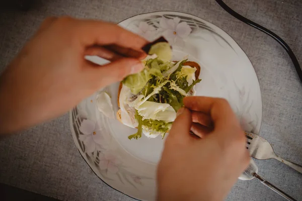 Eine Nahaufnahme Von Händen Die Salat Auf Einen Teller Auf — Stockfoto