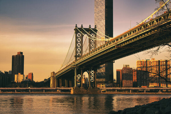 An evening view of the Manhattan Bridge from Dumbo against a colourful sky