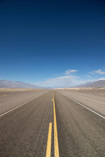 Вертикальный Снимок Дороги Белыми Облаками Заднем Плане — стоковое фото