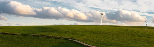 Stormy weather in the spring, clouds in the sky, green meadow, agriculture in Germany, landscape, wind energy and environment discussion, countryside