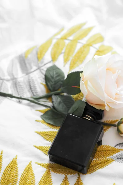 バラと枕の上に高級香水瓶の垂直ショット — ストック写真
