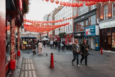 Londra, İngiltere 'de kalabalık bir caddede Çin fenerleri asarak yürüyen insanlar.