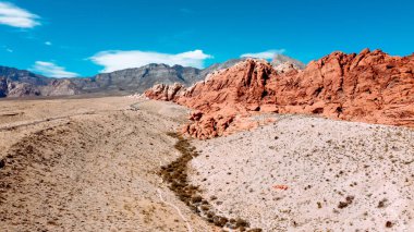 Açık mavi gökyüzünün üzerinde turuncu kayalık uçurumlar