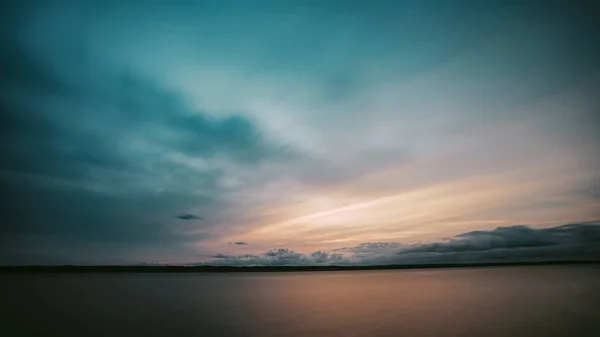 Ein Leicht Bewölkter Himmel Über Ruhigem Meerwasser Bei Sonnenuntergang — Stockfoto