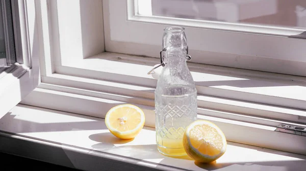 Limone Mezzo Tagliato Accanto Una Bottiglia Vetro Con Succo Limone — Foto Stock