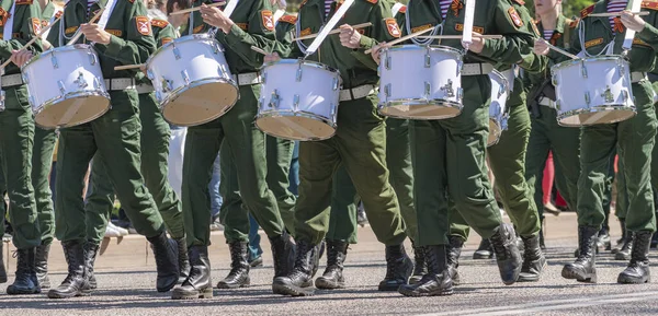 stock image Group of young drummers, dressed in camouflaged military uniforms, marches down city street and plays drums. May 9 is annual victory day holiday.