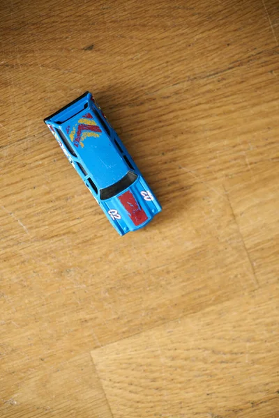 The Mattel Hot Wheels toy model car on a wooden floor
